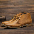 Men's tan lace-up chukka boots on a wooden floor