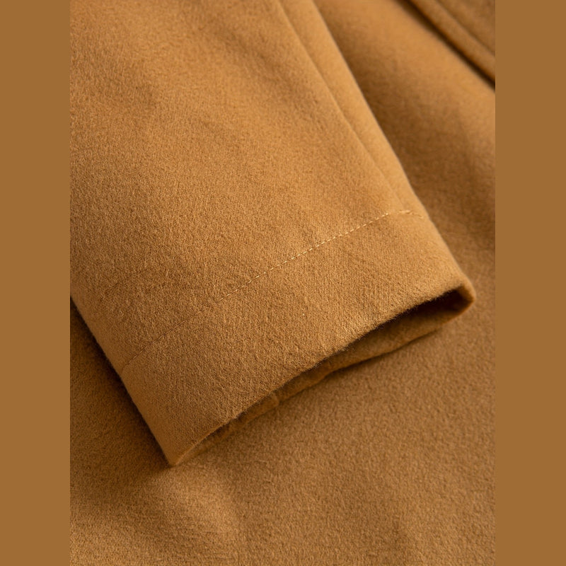 Close-up of the sleeve cuff on the brown overcoat