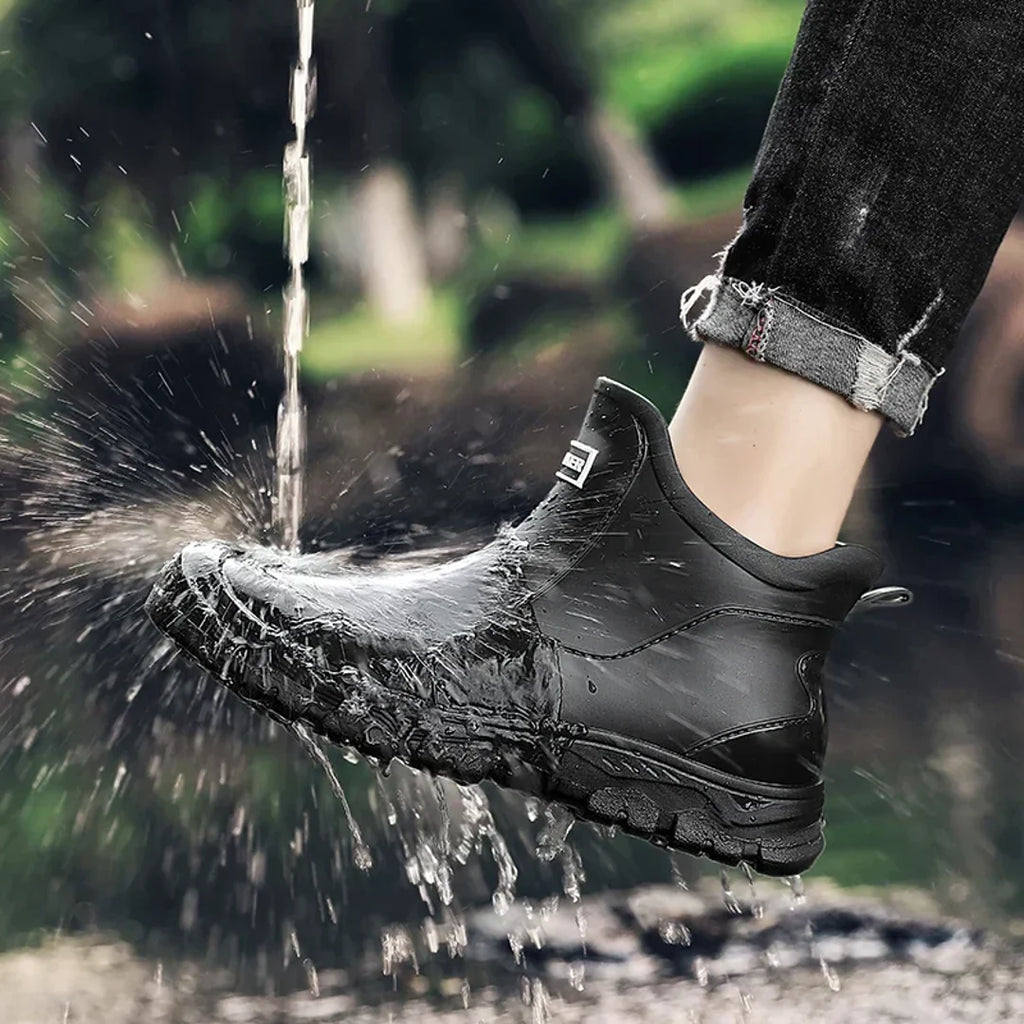 Men's black rain boot splashing through water