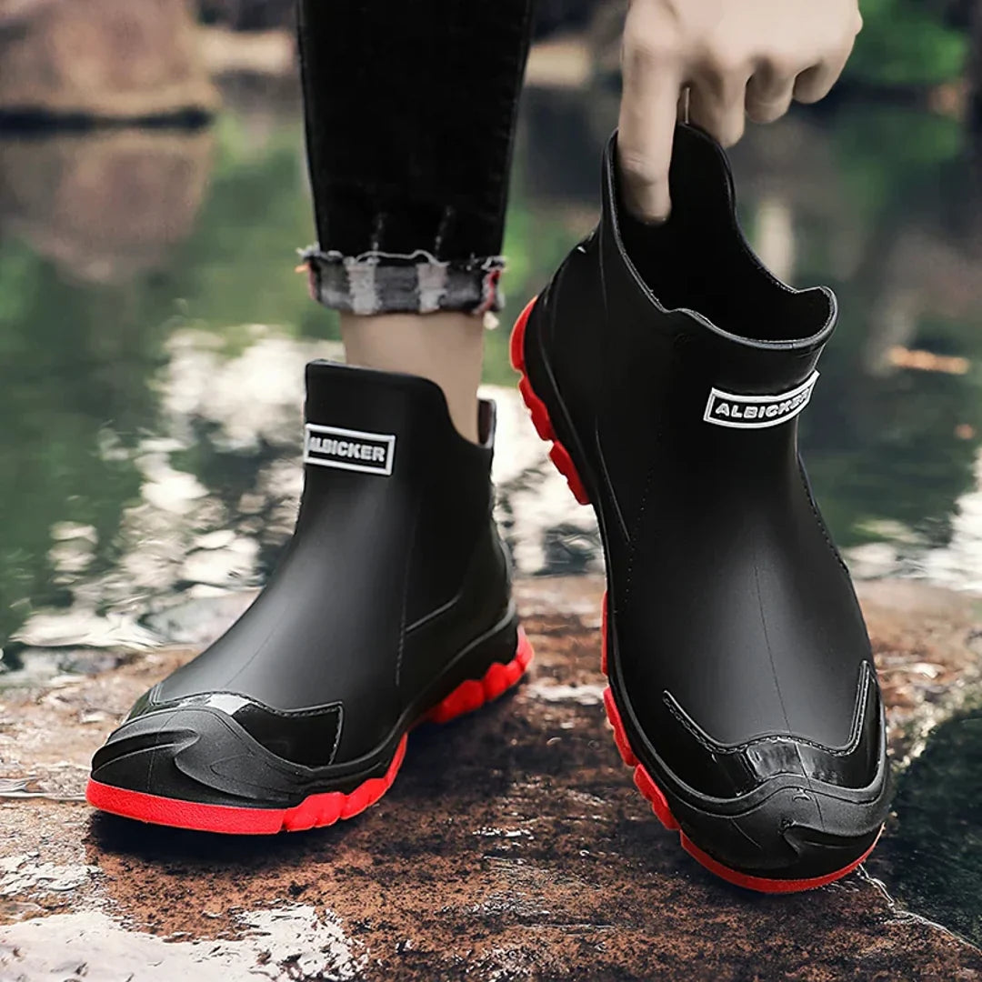 Man pulling on a black rain ankle boot
