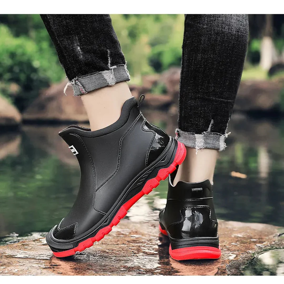 Men's black rain boots with red sole worn outdoors