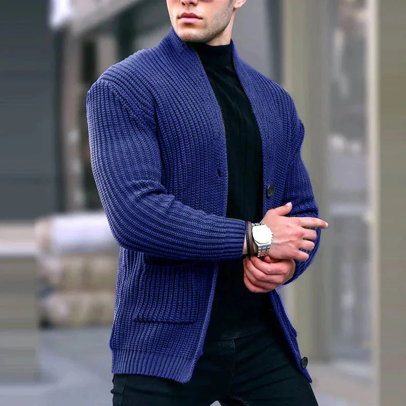 Man wearing dark blue chunky knit cardigan over black turtleneck