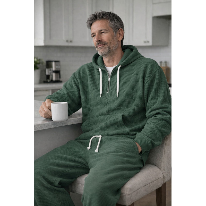Man seated in green hooded tracksuit