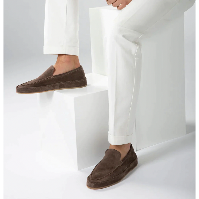 Brown men's slip-on loafers worn on steps