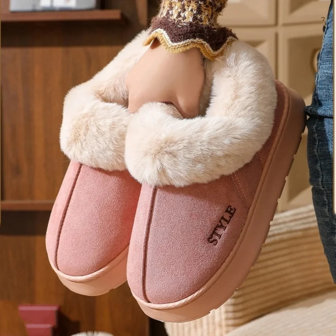 Woman holding pink fluffy slipper boots