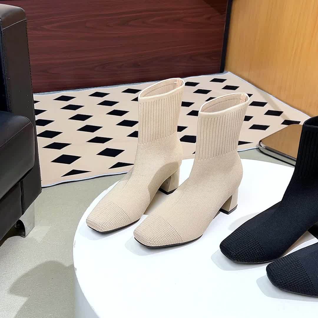 Women's beige and black knit sock boots on a table