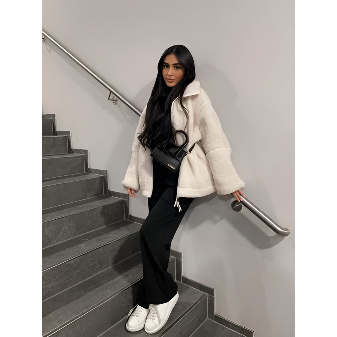 Woman wearing a cream teddy jacket with black trousers