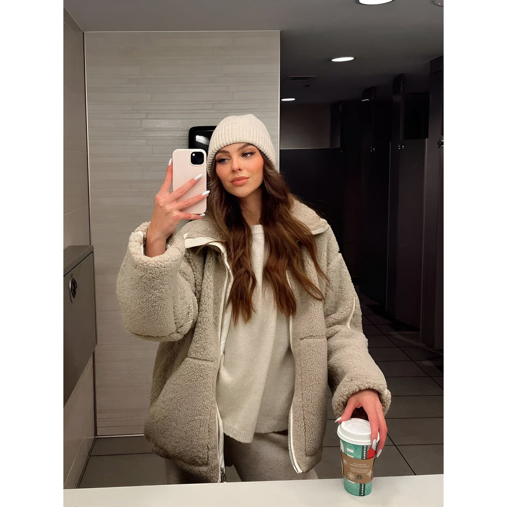 Woman in a cream teddy jacket with a beanie
