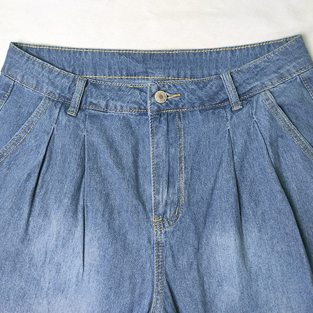Blue pleated wide-leg jeans laid flat – front view