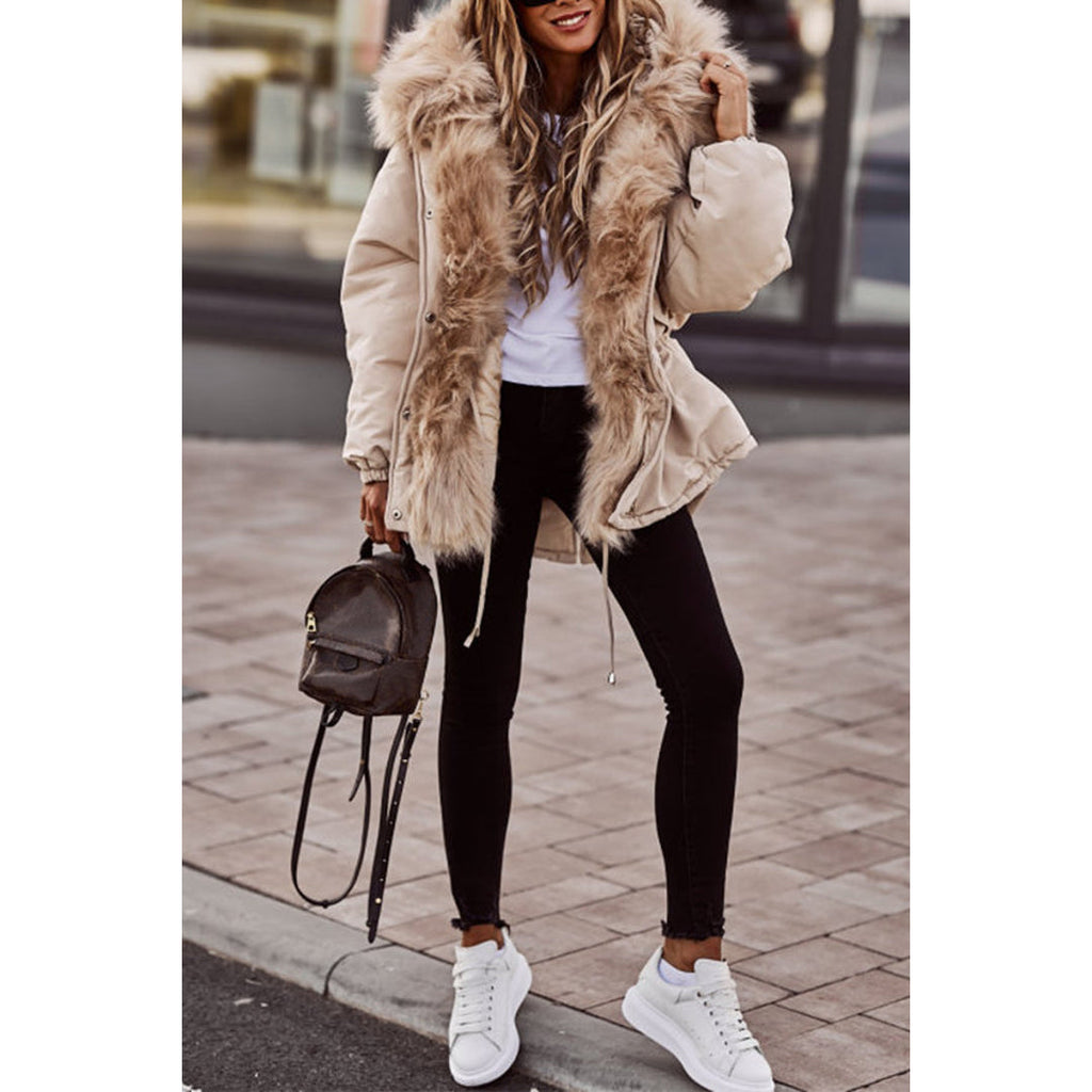 Woman wearing a beige parka with fluffy hood – front view