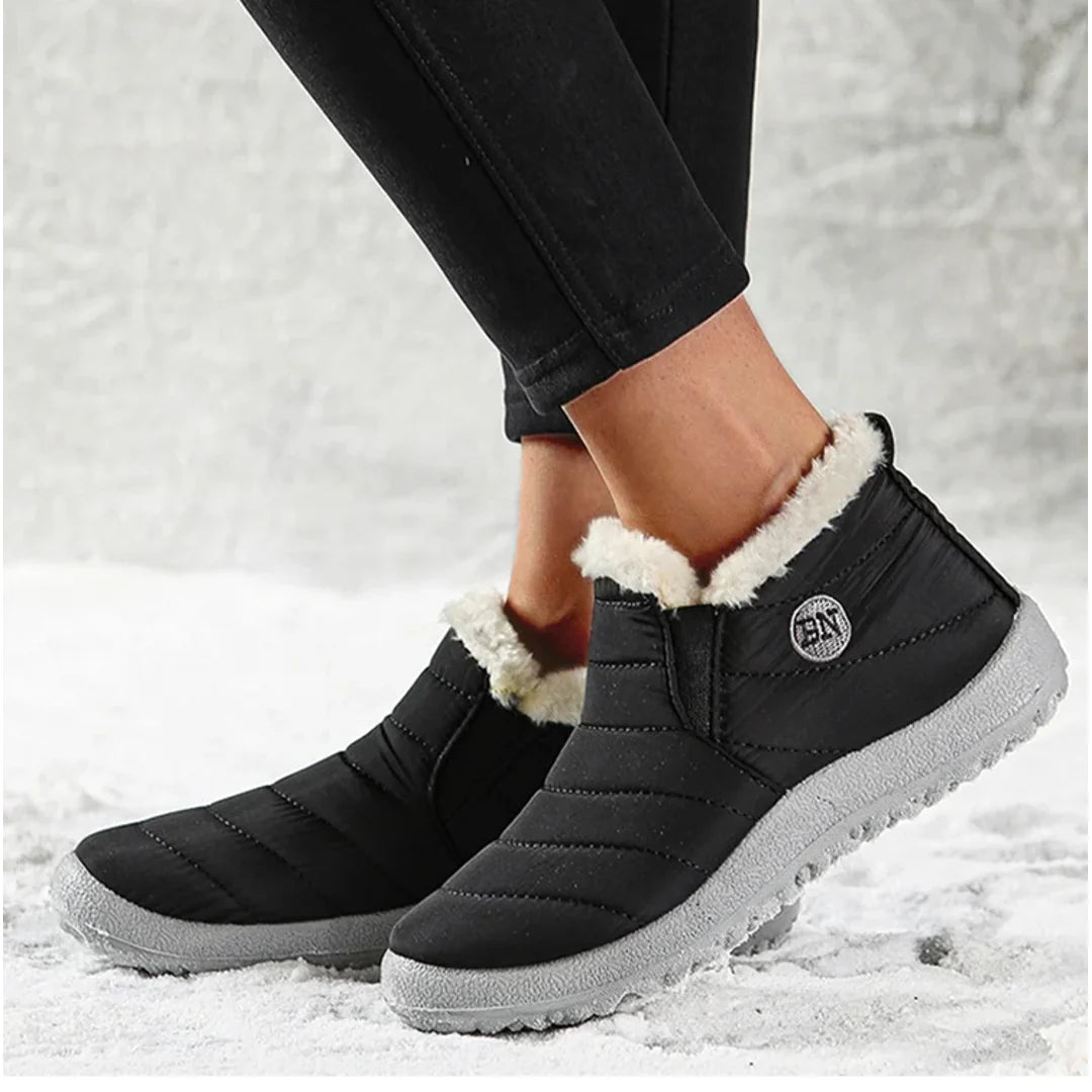 Women's black slip-on winter boots worn outdoors