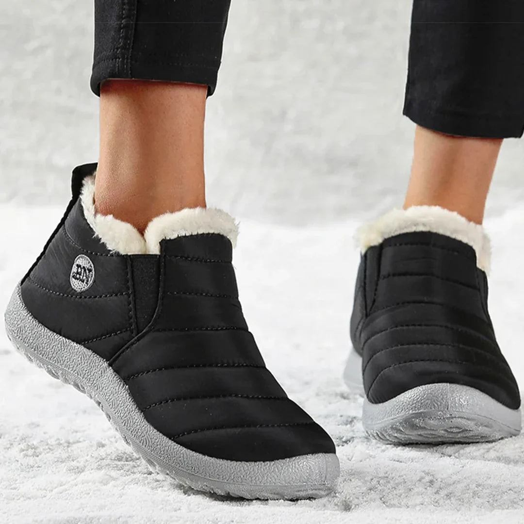 Woman wearing black slip-on winter boots in the snow