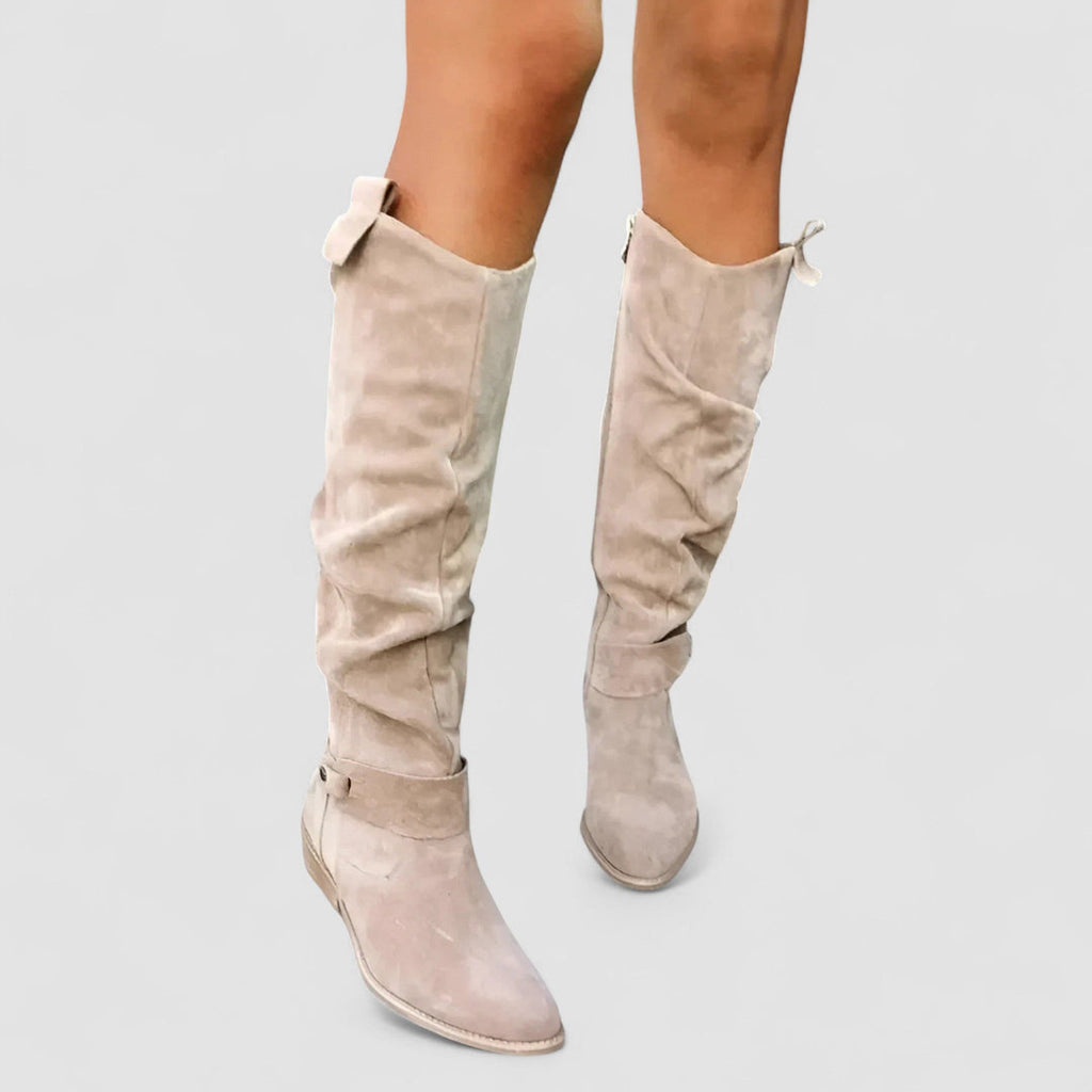 Women's beige knee-high boots worn with a dress