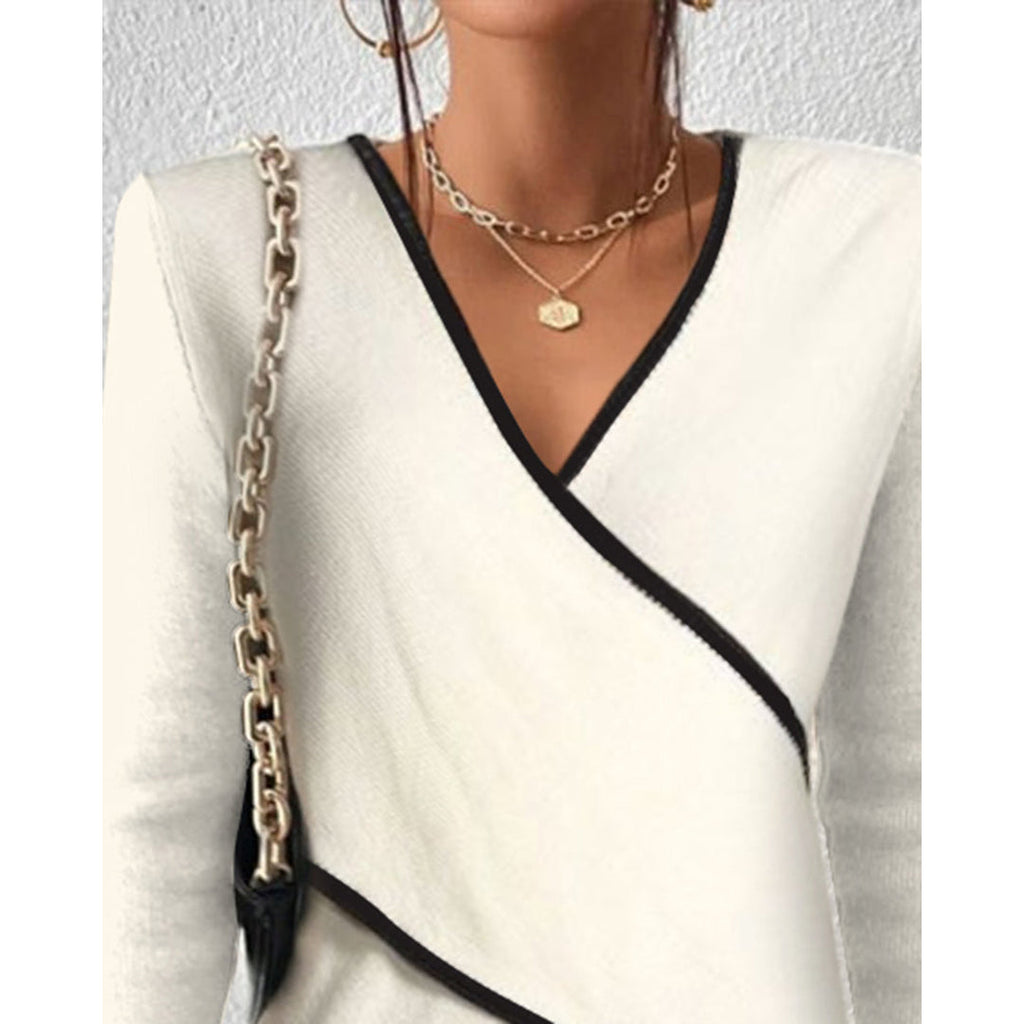 Close-up of the V-neck and black trim on the cream wrap sweater