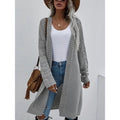 Woman in a long grey open-front cardigan with jeans and a white top