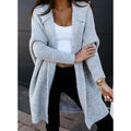 Woman in a light grey open-front shawl cardigan with black trousers