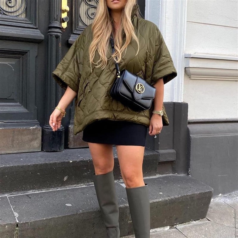 Women's olive green quilted cape jacket worn with knee-high boots