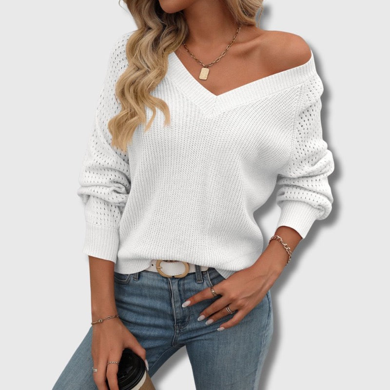 White V-neck sweater worn off the shoulder with jeans